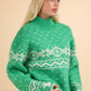 Festive green sweater with snowflake pattern and mock neck, perfect for spreading holiday cheer and warmth in winter.