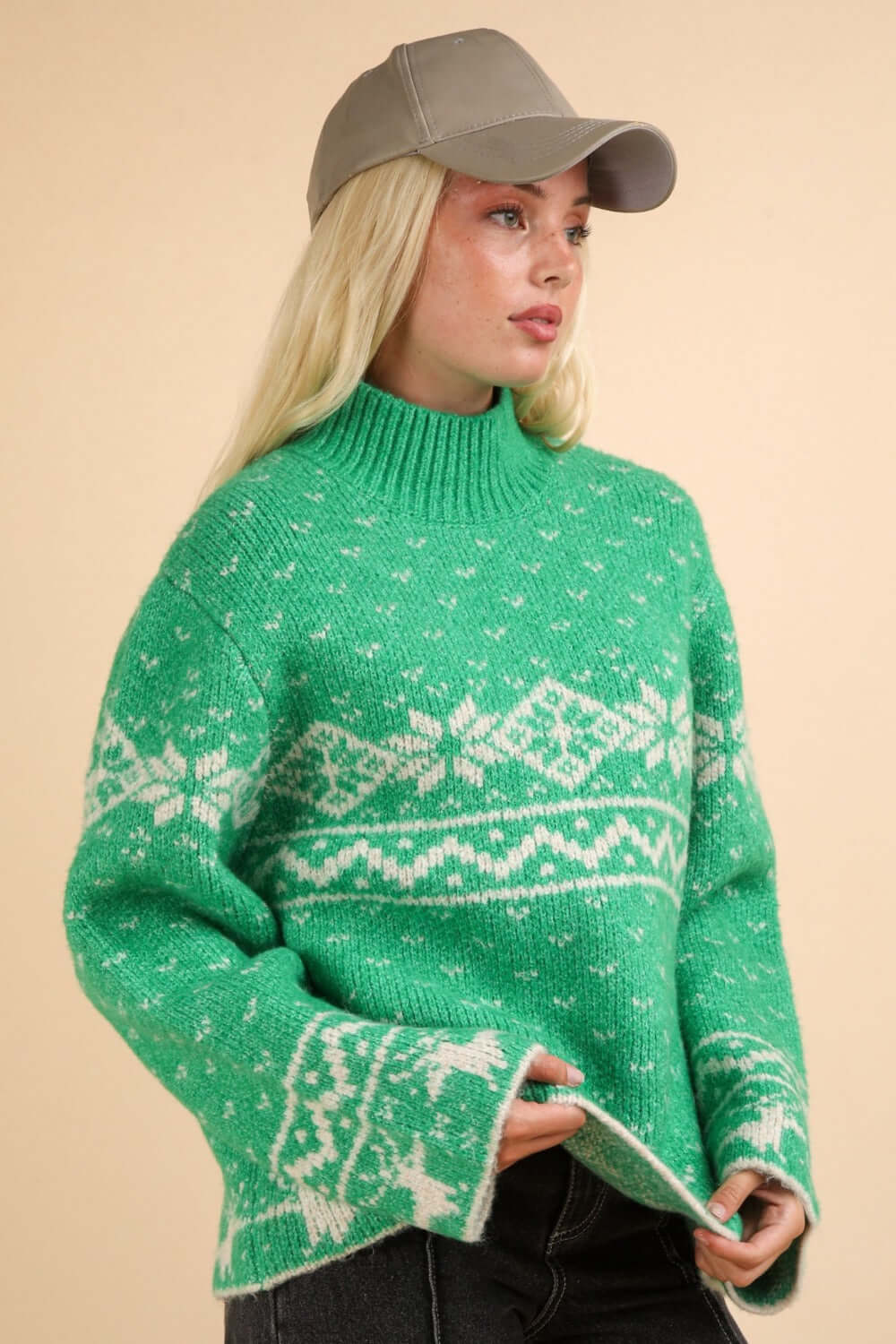 Festive green sweater with snowflake pattern and mock neck, perfect for spreading holiday cheer and warmth in winter.