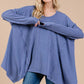 Woman wearing Ces Femme asymmetrical long sleeve top in blue with relaxed fit and hi-low hem for effortless, casual style.