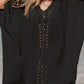 Woman wearing a black cutout V-neck three-quarter sleeve cover up at the beach, featuring sheer openwork design.