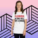 Woman wearing "Florida Is One Hell of a Drug" short-sleeve unisex t-shirt against geometric background