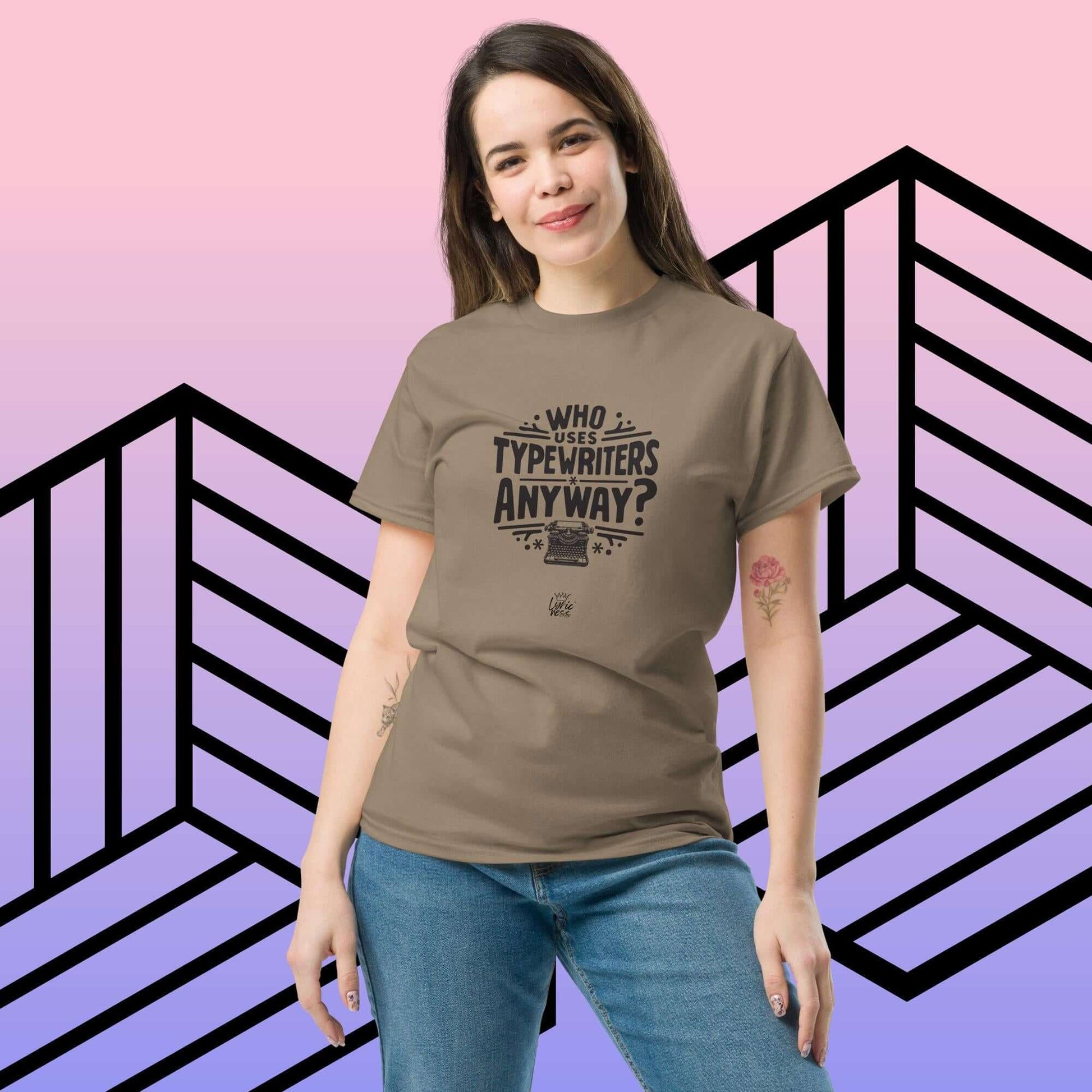 Unisex model wearing brown "Who Uses Typewriters Anyway?" short-sleeve cotton T-shirt against a geometric background.