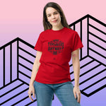 Person wearing red "Who Uses Typewriters Anyway" short-sleeve unisex t-shirt.