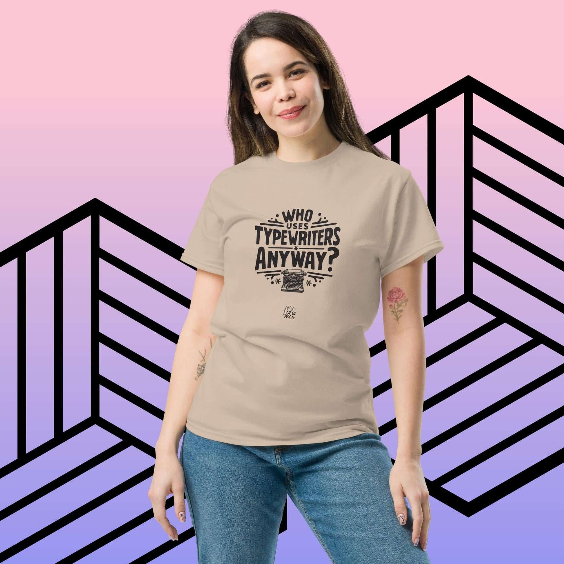 Model wearing "Who Uses Typewriters Anyway?" unisex short-sleeve T-shirt in beige, styled casually with jeans against a geometric backdrop.