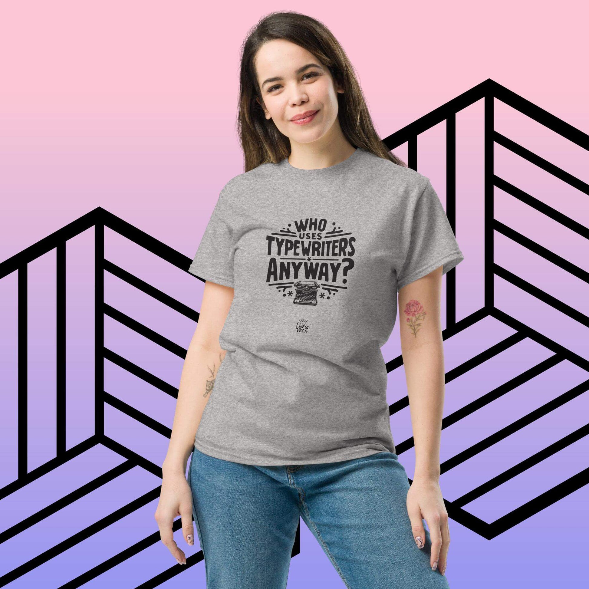 Woman wearing "Who Uses Typewriters Anyway?" short-sleeve unisex t-shirt in sport grey, with geometric background.