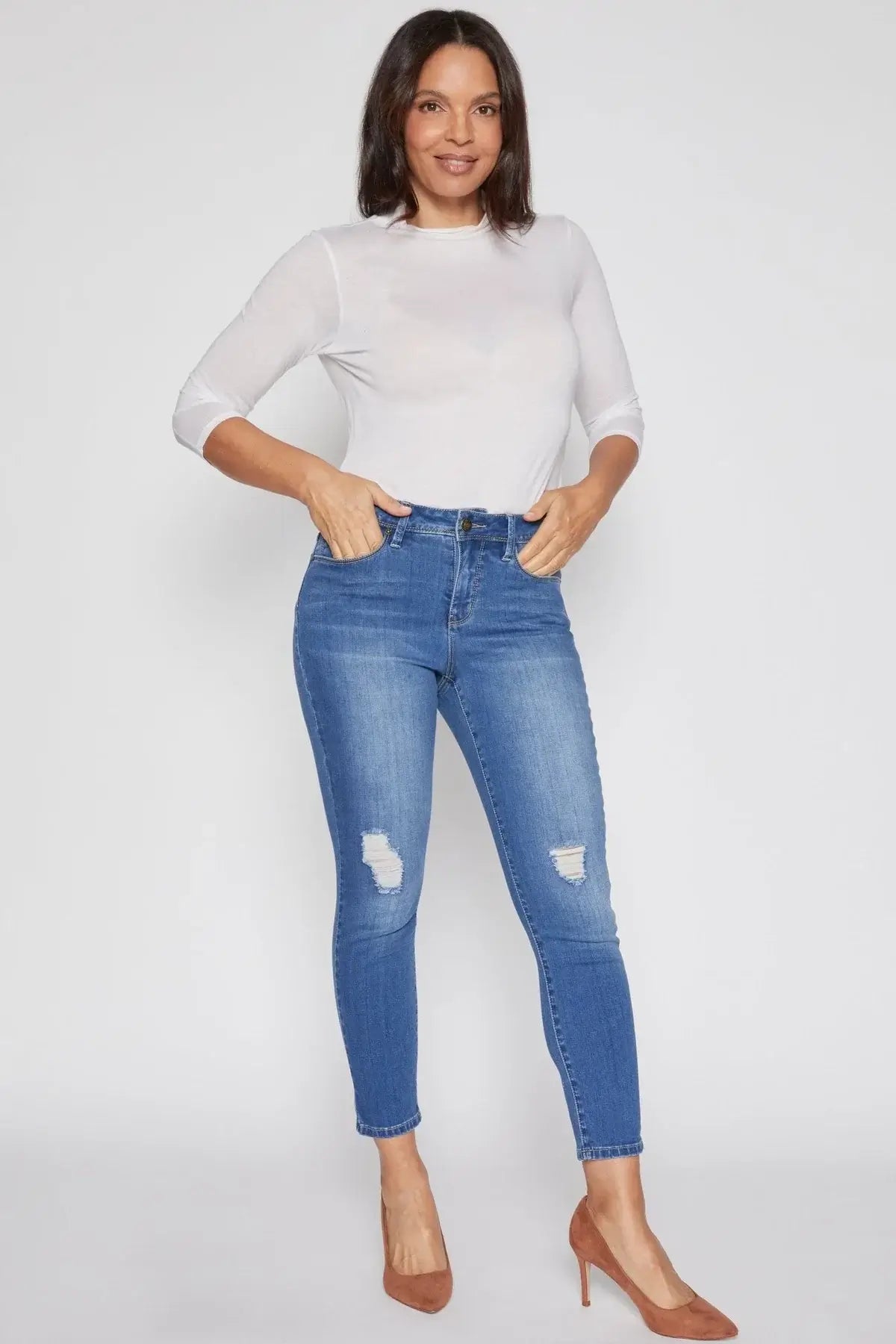 Woman wearing YMI Jeans Missy Petite Hide Your Muffin Top Classic Skinny Jeans, styled with a white blouse and heels.